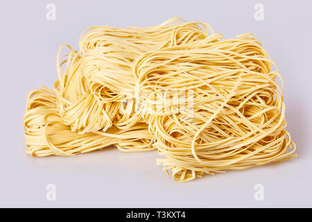 Nouilles laminées sèches d'épaisseur de forme carrée. Capelli d'angelo, les cheveux d'Ange - pâtes. Les pâtes italiennes tagliatelles faites maison. La cuisine italienne. Les nouilles aux oeufs. Banque D'Images