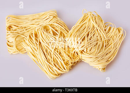 Nouilles laminées sèches d'épaisseur de forme carrée. Capelli d'angelo, les cheveux d'Ange - pâtes. Les pâtes italiennes tagliatelles faites maison. La cuisine italienne. Les nouilles aux oeufs. Banque D'Images