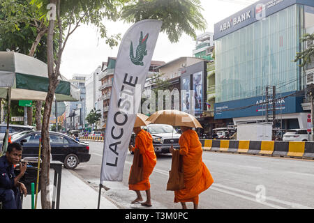 Funny rue phnom penh capte avec biddhist monks à pied par la route principale et les banques et les marques de luxe Banque D'Images