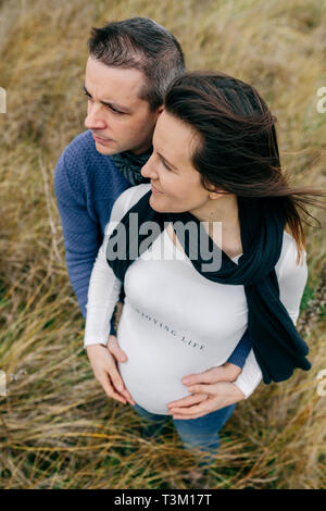 Enceinte avec partner hugging and holding belly Banque D'Images