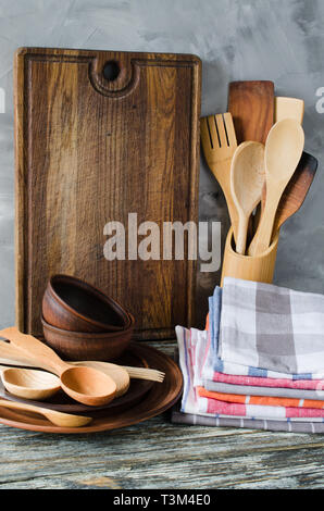 De simples ustensiles de cuisine : plaques en céramique rustique en bois ou bambou, couverts, serviettes et planche à découper vintage dans l'intérieur de la cuisine. Style rustique. Accueil Kitch Banque D'Images