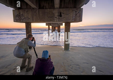 Les touristes de prendre des photos du lever du soleil à la Saint John's County Ocean Pier, le 21 mars 2016, à Saint Augustine, en Floride. Banque D'Images