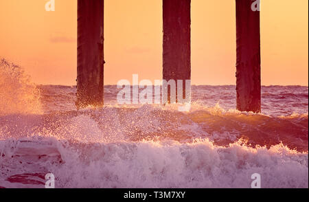 Le soleil se lève sur le fracas des vagues sur la jetée, comté de Saint John's, le 21 mars 2016, à Saint Augustine, en Floride. Banque D'Images