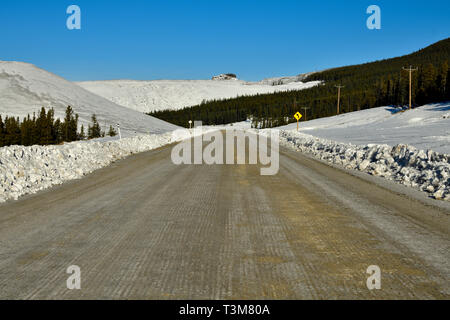Une image paysage rural d'un gravier qui a été effacée de la neige et de la glace avait retiré de la chaussée dans la montagnes rockey d'Albert Banque D'Images