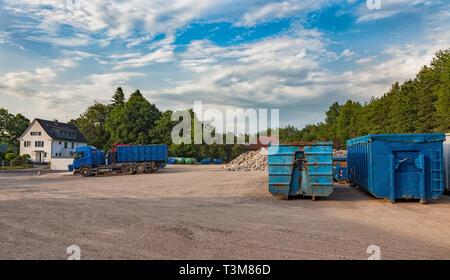 Chantier de recyclage avec des camions et des conteneurs différents Banque D'Images