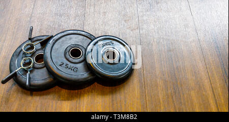 Black Metal les disques des haltères courtes sur le sol dans la salle de remise en forme Banque D'Images