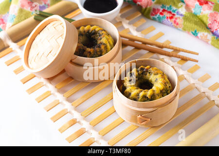 Concept alimentaire asiatique des Dim Sum à la vapeur boulettes frites de l'ail chinois Dim Sum en panier-vapeur en bambou sur fond blanc Banque D'Images