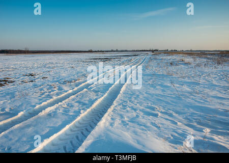 Les traces du véhicule sur la neige vers l'horizon - vue d'hiver Banque D'Images