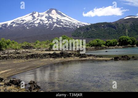 Llaima Conguillio volcan au NP dans le centre du Chili - Vue sur le lac sur pic noir avec des taches isolées de neige Banque D'Images