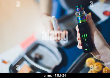 IQOS-chaleur-pas brûler du tabac produit de la technologie. Woman holding e-cigarette dans sa main avant de fumer. et vape Banque D'Images