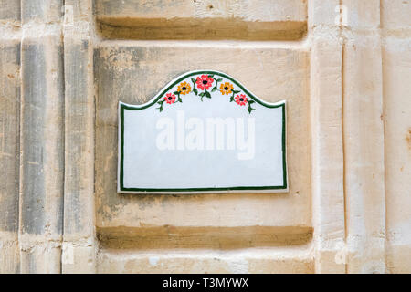 Accueil traditionnel maltais signer à Gozo, peint sur les carreaux de céramique placé sur le mur de pierre sans texte à l'intérieur Banque D'Images