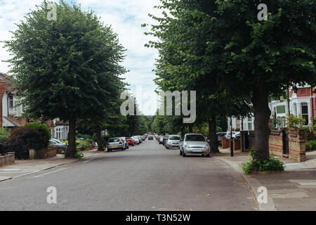 Rue typique de la banlieue de Londres avec des maisons mitoyennes et de tilleuls le long de lui Banque D'Images