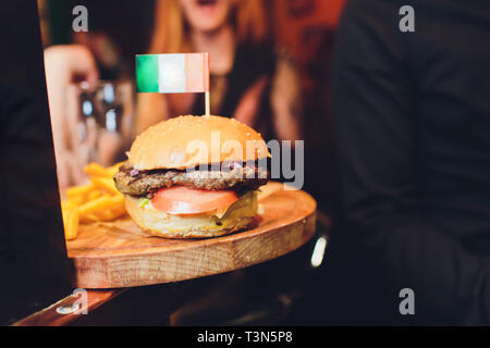 Burger avec drapeau irlandais sur le dessus. Fond de bois. Close up Banque D'Images