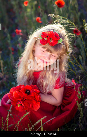 Belle fille blonde avec du maïs rouge coquelicot Banque D'Images