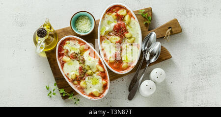 Bannière de l'Italien boulettes de pommes de terre gnocchi alla sorrentina de fromage mozzarella, cuit au four avec une sauce tomate et fines herbes. Servi avec du parmesan Banque D'Images
