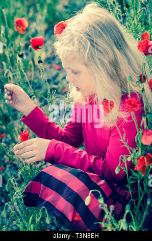 Belle fille blonde avec du maïs rouge coquelicot Banque D'Images