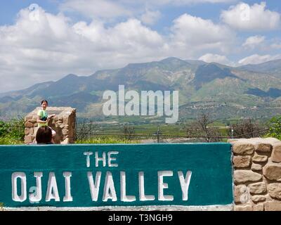 Deux jeunes filles, âgées de 10 et 12, en face de l'Ojai Valley signe avec vue sur la vallée, Ojai Valley, Californie, USA. Banque D'Images