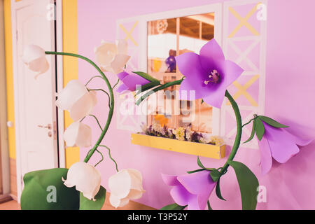 Fleurs en papier et carton ondulé sur le mur Banque D'Images