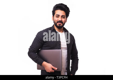 Bel homme arabe holding laptop en mains et d'écrire quelque chose d'isolé sur fond gris Banque D'Images