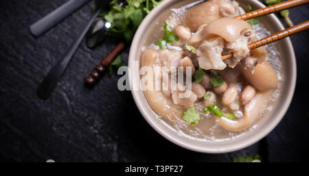 Vue de dessus, Close up, de copie, de l'espace asiatique de Taiwan, de l'alimentation de rue distinctif jarret de porc d'arachide dans un potage crémeux ivoire beige-blanc Couleur bol isolé sur Banque D'Images