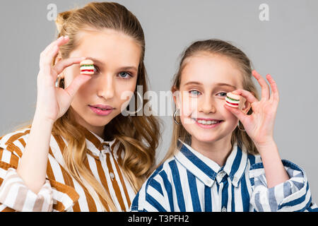 Appel positif les filles aux yeux bleus montrant de petits hamburgers Banque D'Images