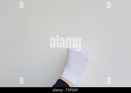 Chaussures de ballet Ballet danseuse attachant. Close up ballet girl putting sur ses pointes assis sur le plancher, arrière-plan flou. Banque D'Images