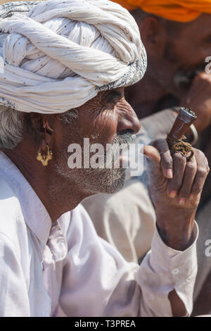 PUSHKAR, INDE - 21 NOVEMBRE 2012 : Portrait d'un homme non identifié du Rajasthan indien fumant une pipe Banque D'Images