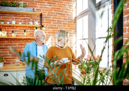 Les grands-parents en agitant les mains et en regardant par la fenêtre Banque D'Images