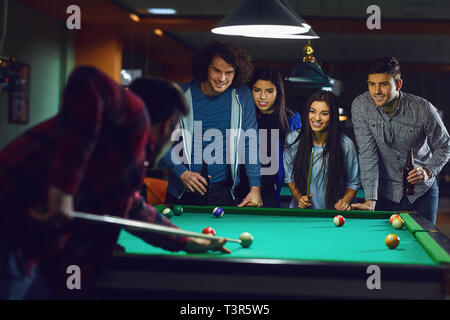 Les amis jouer au billard dans un bar. Banque D'Images