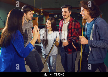 Groupe d'amis rire dans le club de billard. Banque D'Images