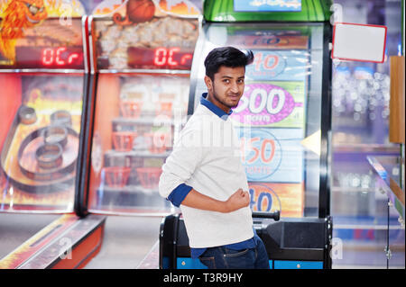 Young Asian man jouer sur les machines à sous roue de fortune pour essayer de gagner au grand prix de loterie. Jouer jackpot spin. Tambour rond argent casino jeu. Banque D'Images