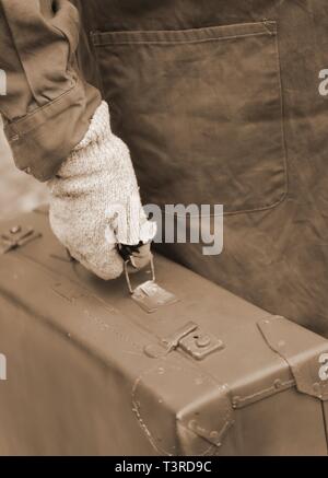 Valise en cuir avec l'homme et des gants pendant le voyage avec tonique effet sépia Banque D'Images