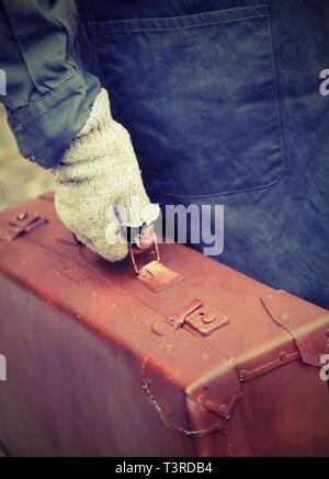 Pauvre homme avec valise en cuir et gants cassée avec de vieux effet tonique Banque D'Images