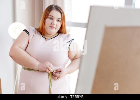 Belle femme aux cheveux rouges qui veulent perdre du poids Banque D'Images