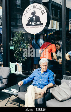 Londres/UK - 20 juillet 2018 : un homme âgé se reposant dans une chaise dans la rue café à Londres Banque D'Images