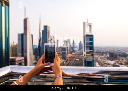 Woman taking photo de Dubai cityscape par téléphone Banque D'Images