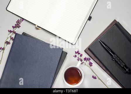 Tasse de thé avec composition télévision, livres, plaquettes, stylo, violet fleurs sèches Banque D'Images