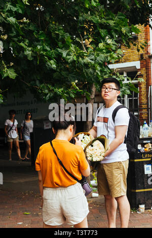 Londres/UK - 22 juillet 2018 : Asian woman photographing fleurs achetées sur le marché aux fleurs de la Colombie-Britannique à Londres Banque D'Images