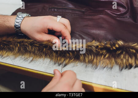 Sur mesure, designer professionnel réparation de manteau de fourrure à l'atelier, studio. La mode et la couture concept. Banque D'Images