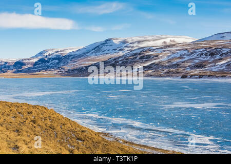 La voie de circulation 60 nord le long d'un lac dans l'Westfjords de l'Islande, grâce à des conditions d'hiver Banque D'Images