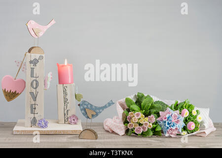 Décoration de table fait maison pour le printemps. Bois équarri peint en blanc. Texte anglais : l'amour au printemps dans un style de lettrage. Oiseaux, papillons et coeur en Banque D'Images