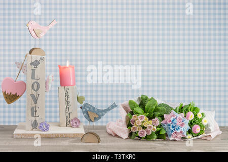 Décoration de table fait maison pour le printemps. Bois équarri peint en blanc. Texte anglais : l'amour au printemps dans un style de lettrage. Oiseaux, papillons et coeur en Banque D'Images