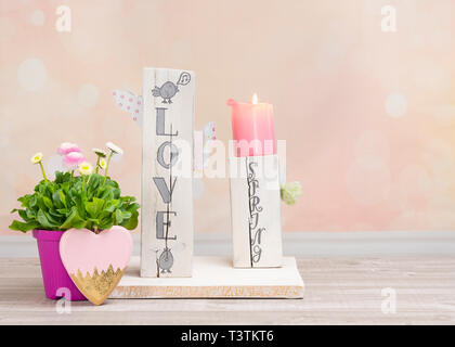 Décoration de table fait maison pour le printemps. Bois équarri peint en blanc. Texte anglais : l'amour au printemps dans un style de lettrage. Oiseaux, papillons, l'écoulement printanier Banque D'Images