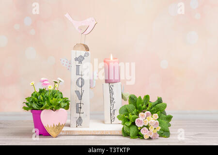 Décoration de table fait maison pour le printemps. Bois équarri peint en blanc. Texte anglais : l'amour au printemps dans un style de lettrage. Oiseaux, papillons, l'écoulement printanier Banque D'Images