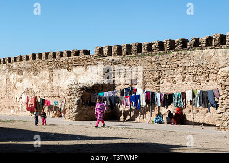 Les femmes en attente de leur lessive à faire sécher par la Médina murs dans Essaouira, Maroc Banque D'Images