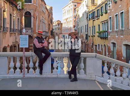Deux gondoliers, les hommes sur un pont de Venise en attente pour les clients Banque D'Images