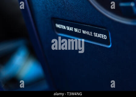 Bari, Italie - 8 mars, 2019 : Avis d'attacher la ceinture de sécurité sur le dos d'un siège d'avion. Banque D'Images