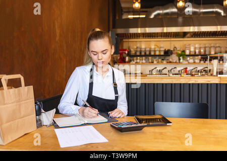 Small family restaurant owner doing finance calculating bills and profit of small business Banque D'Images