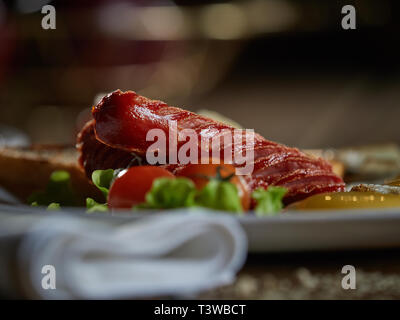 Plusieurs oeufs frits sont servis sur une assiette avec de la saucisse et salade verte avec des tomates rouges frais. Banque D'Images