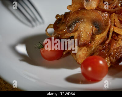 Les petites coupes de viande cuite avec les champignons et les oignons frits sont servis à la table pour le dîner. Banque D'Images